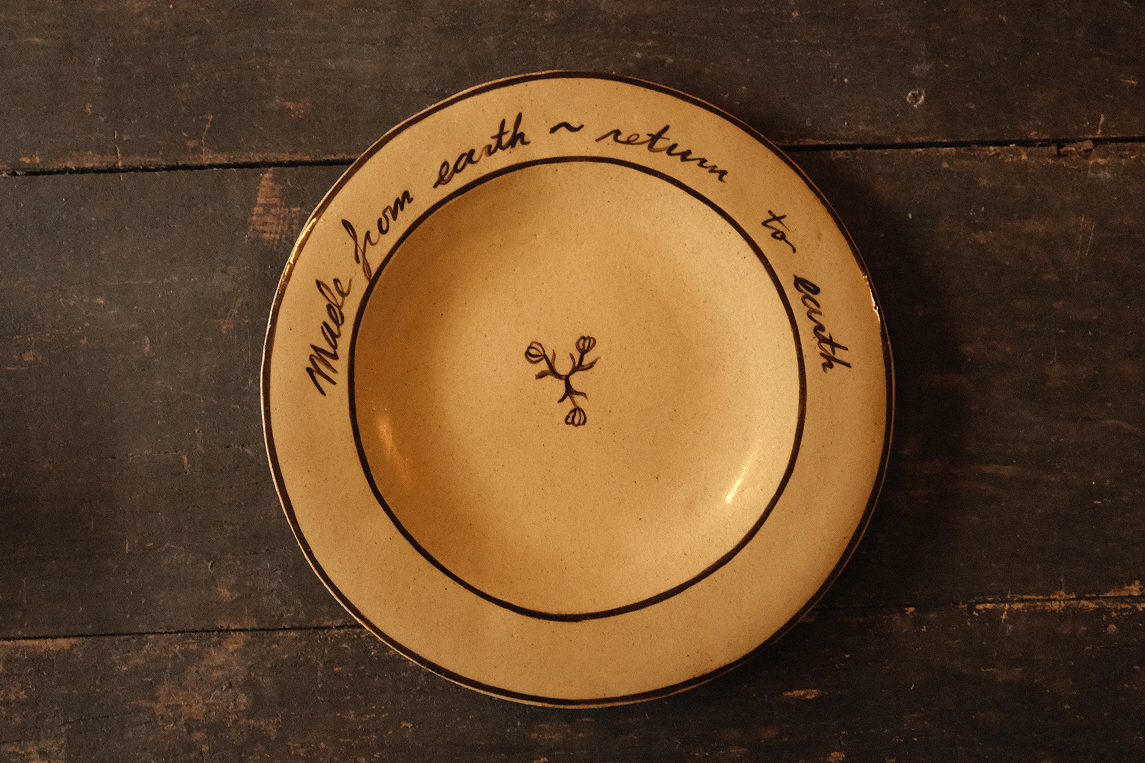 Ceramic plate with text on a wooden surface