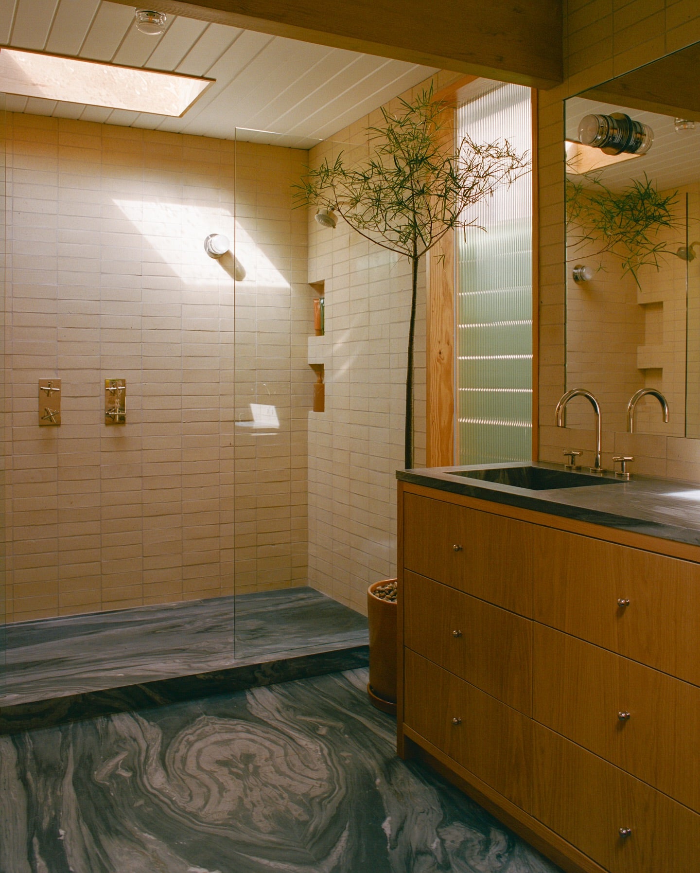 a brick tiled shower in a modern bathroom