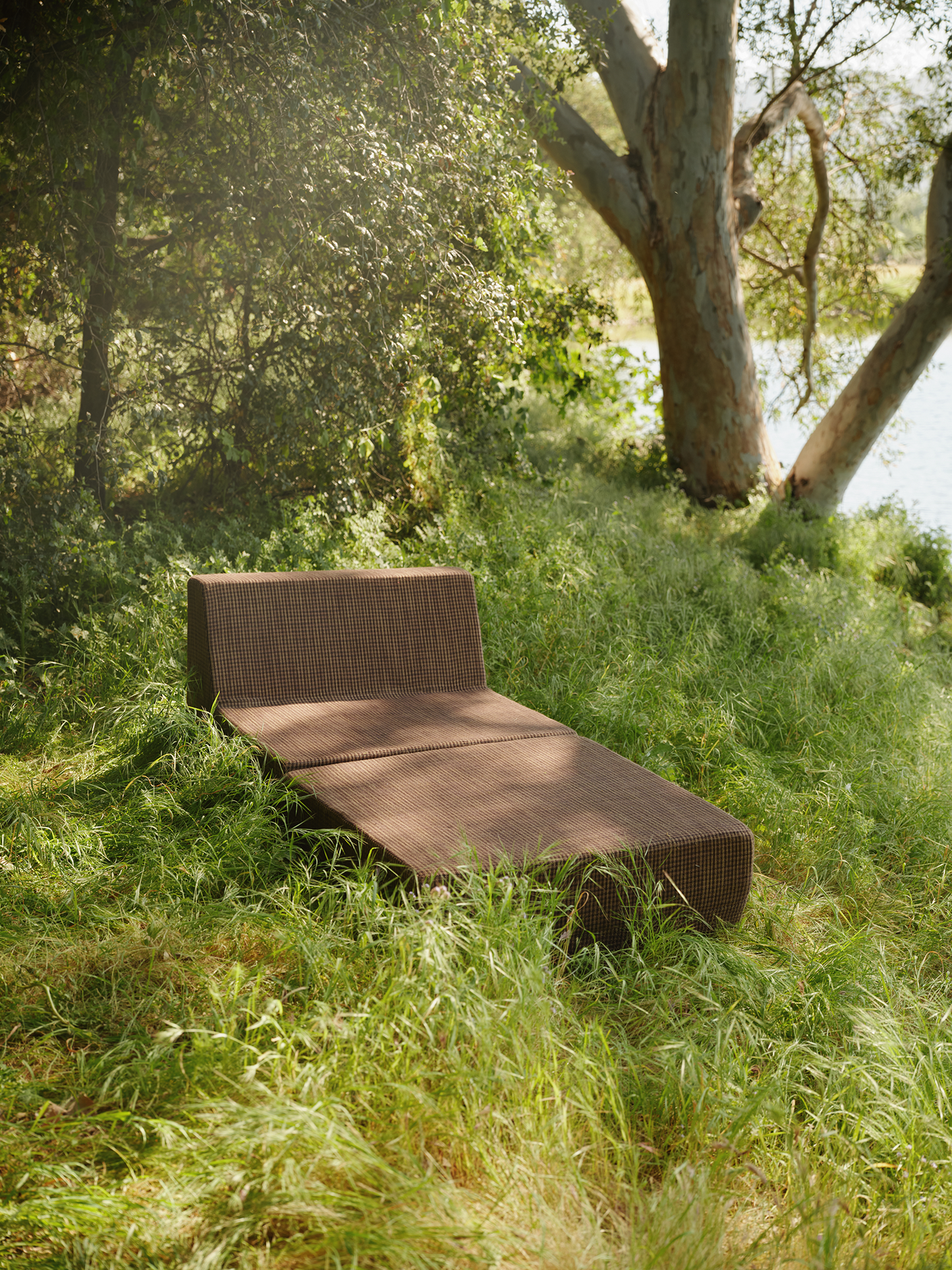 Brown folding outdoor lounge chaise in meadow
