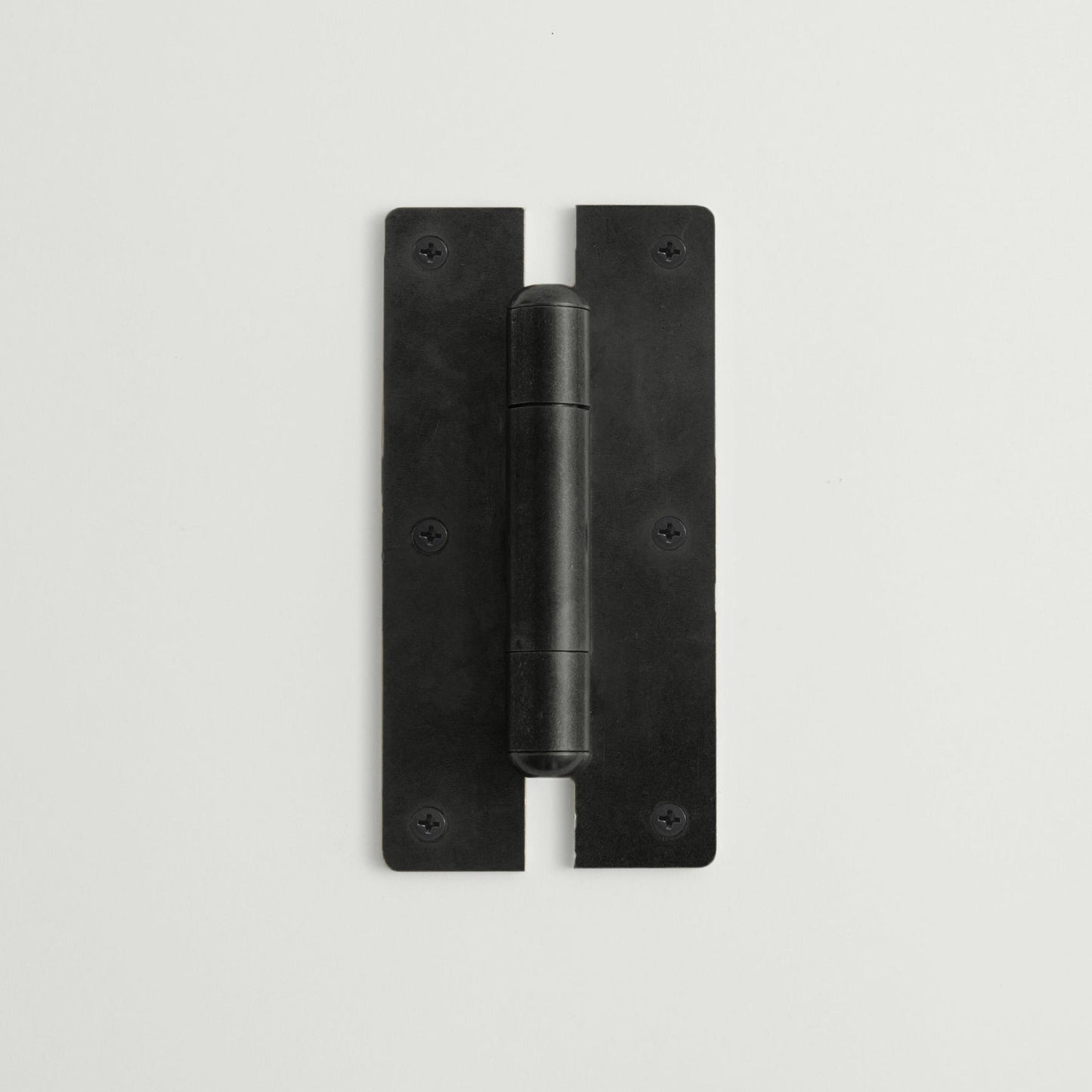 Black metal hinge on a light gray background