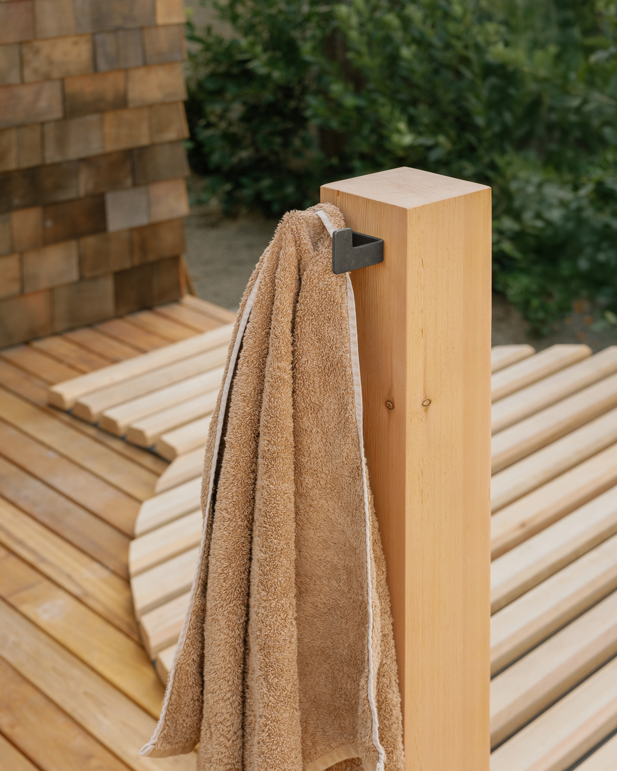 small black hook with towel on wood post