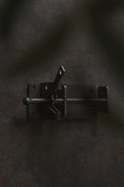 Black metal latch on a dark textured surface