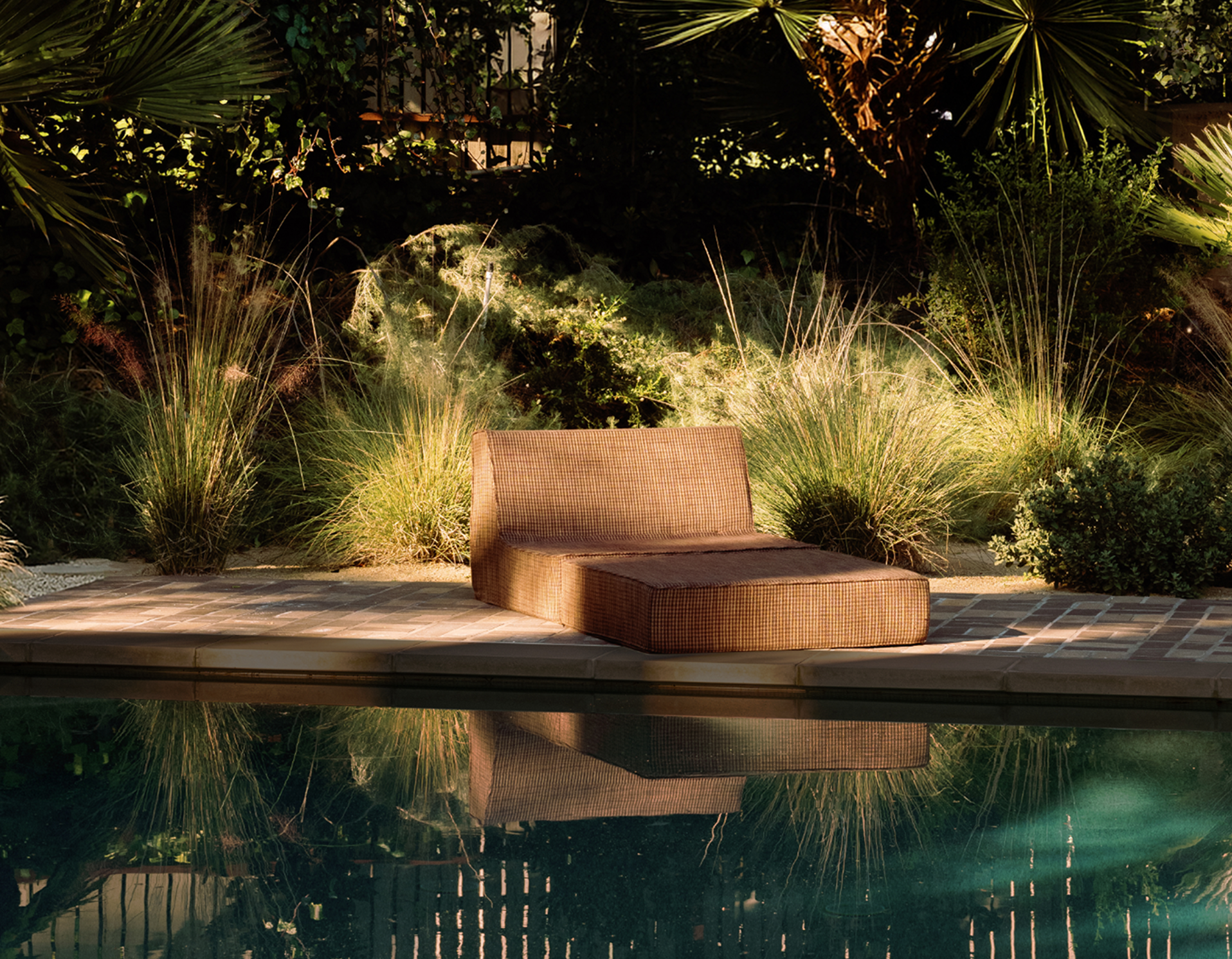 outdoor garden lounge chair next to a pool