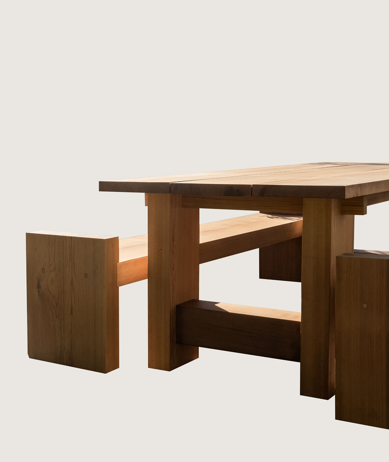 Wooden picnic table with benches on a light gray background