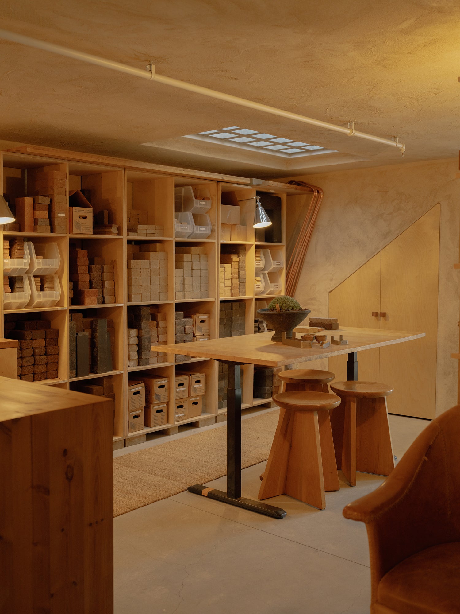 Wooden interior with shelves, table, and chairs in a warm-toned room.
