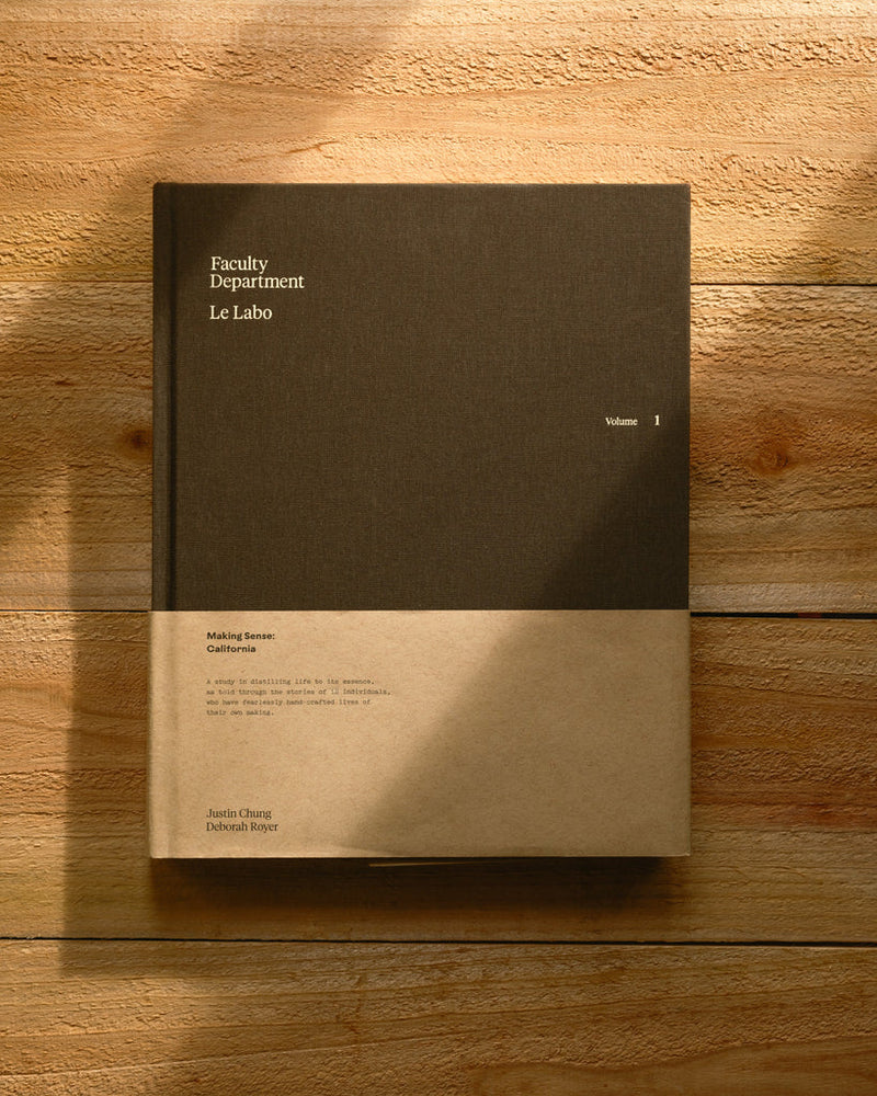 A book titled 'Family Department Job' with a plain black cover and text, placed on a wooden surface with a shadow falling over part of the image.