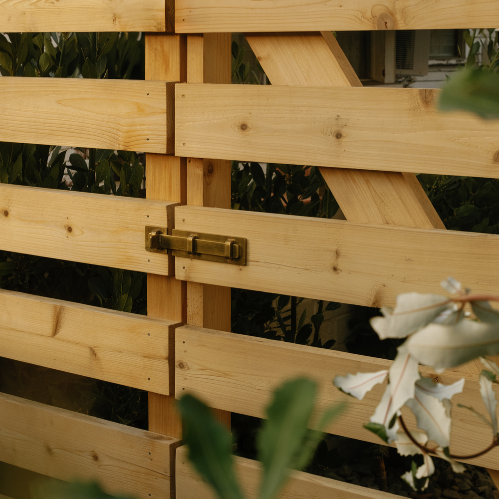raw brass slide bolt installed on wooden gate