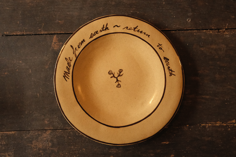 Ceramic plate with text on a wooden surface