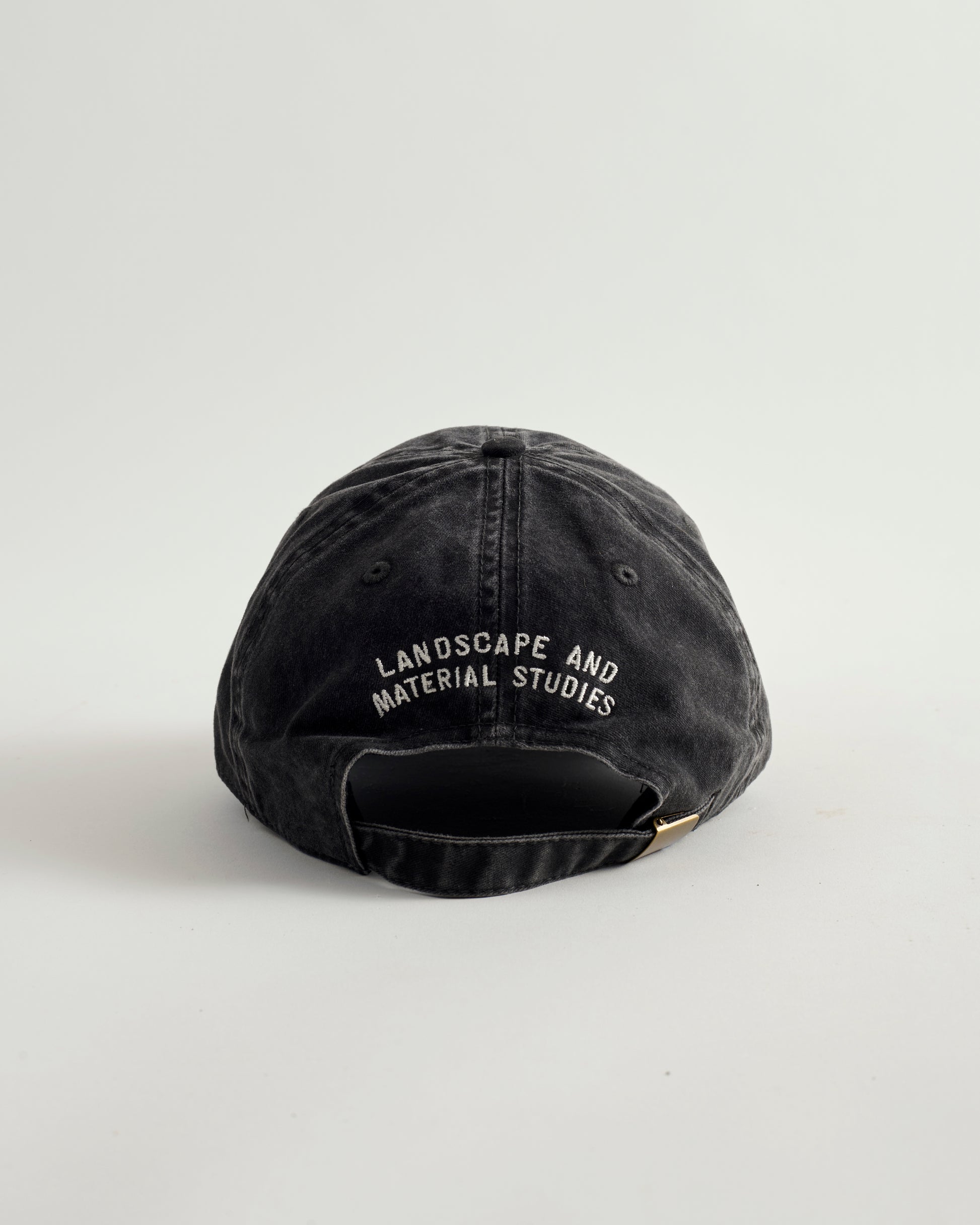 Black cap with 'Landscape and Material Studies' text on a white background