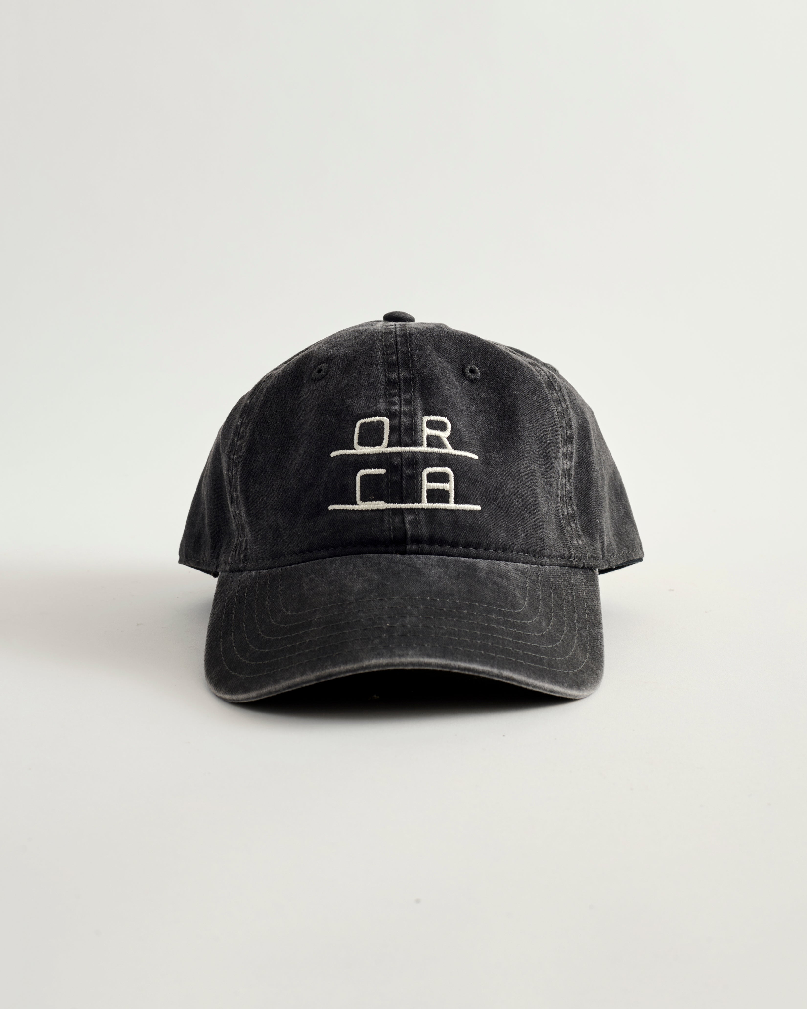 Black cap with white logo on a light gray background