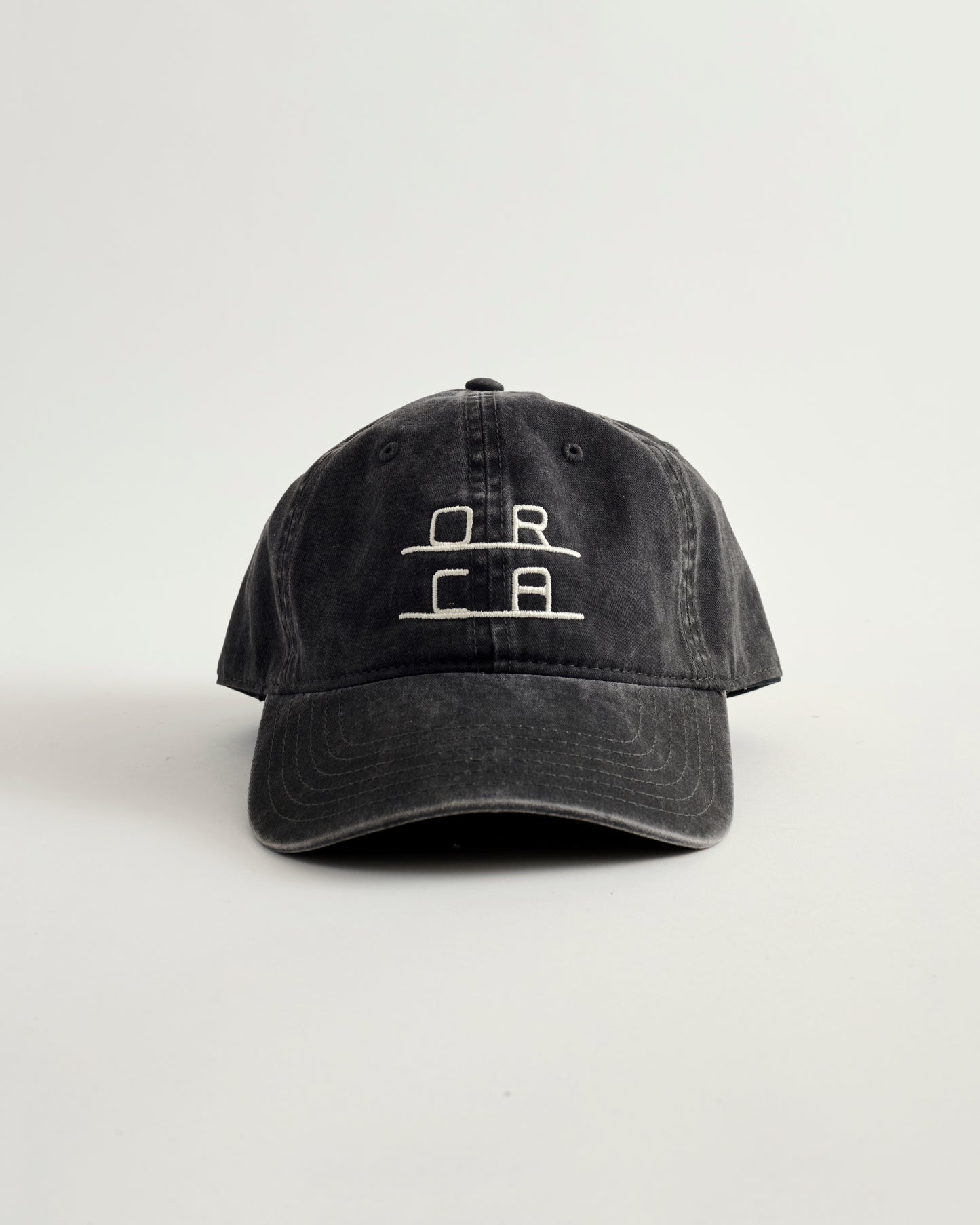 Black cap with white logo on a light gray background