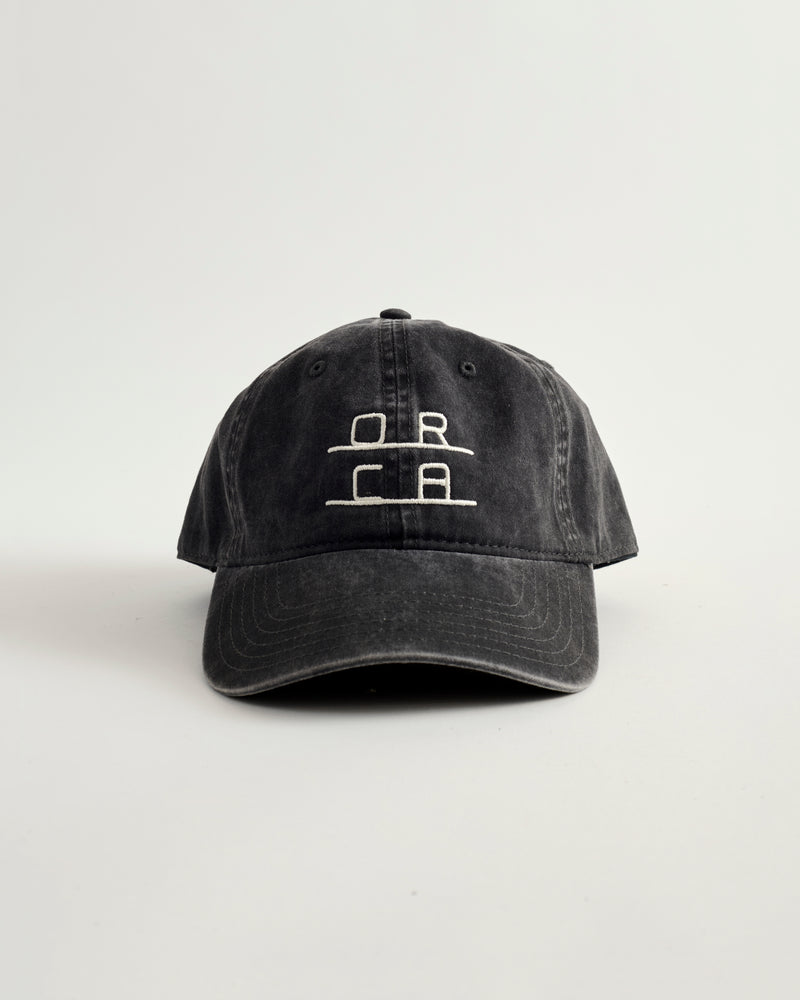 Black cap with white logo on a light gray background