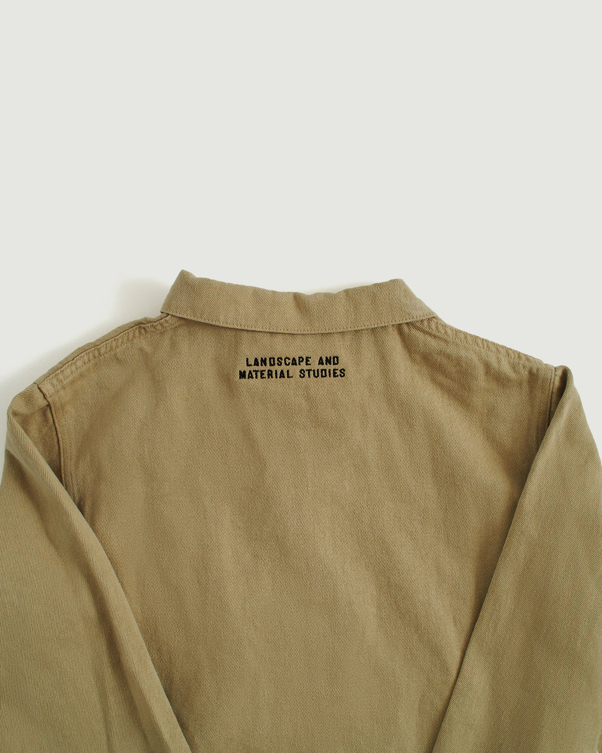 beige field jacket, landscape and material studies embroidered under collar