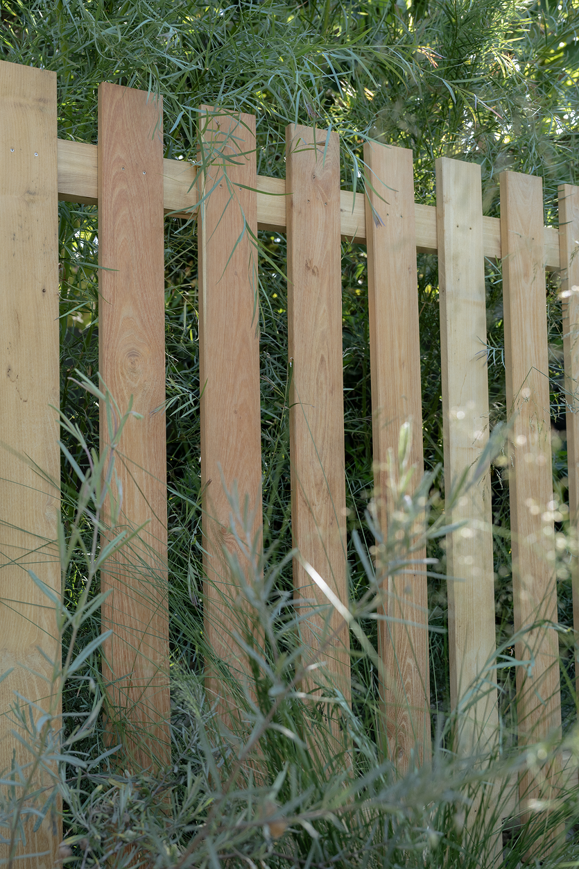 Wooden fence with greenery in the background
