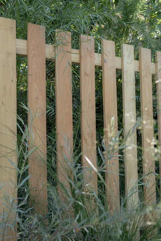 Wooden fence with greenery in the background