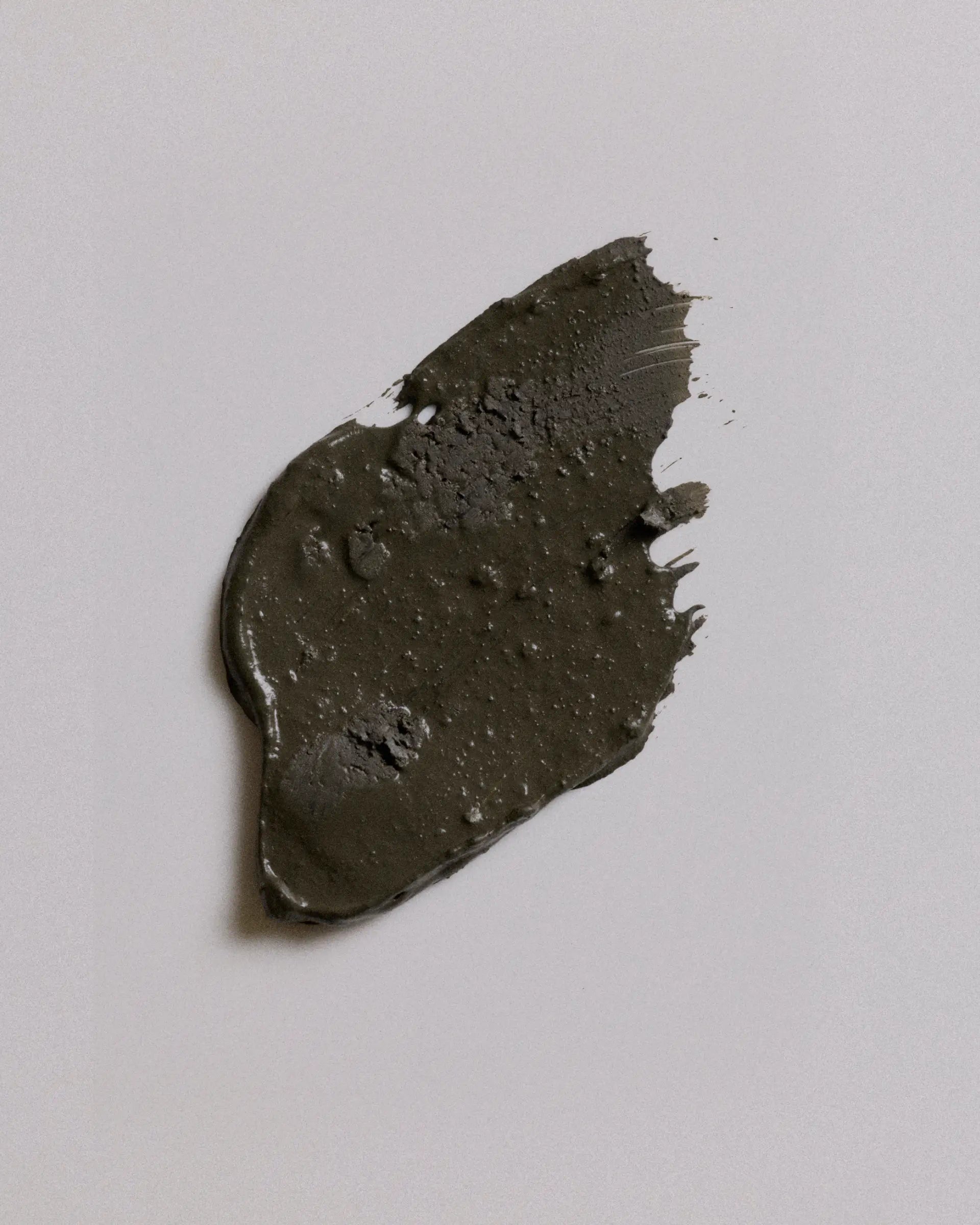 A smudge of camouflage earth coat on a plain light gray background.