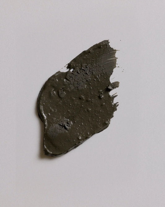 A smudge of camouflage earth coat on a plain light gray background.