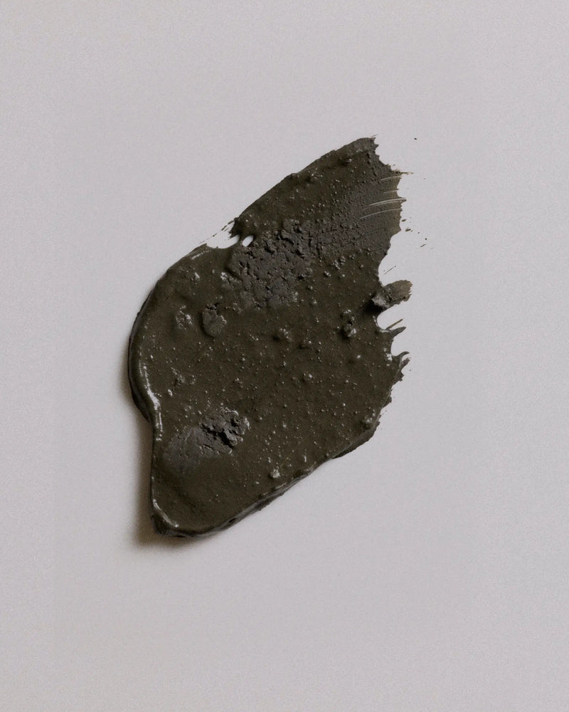A smudge of camouflage earth coat on a plain light gray background.
