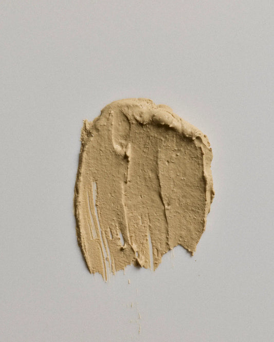 A textured smear of canvas earth coat on a neutral light gray background.