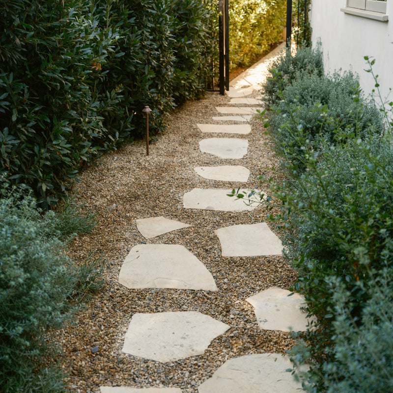 Garden pathway made of Ecru flagstone stepping stones surrounded by greenery