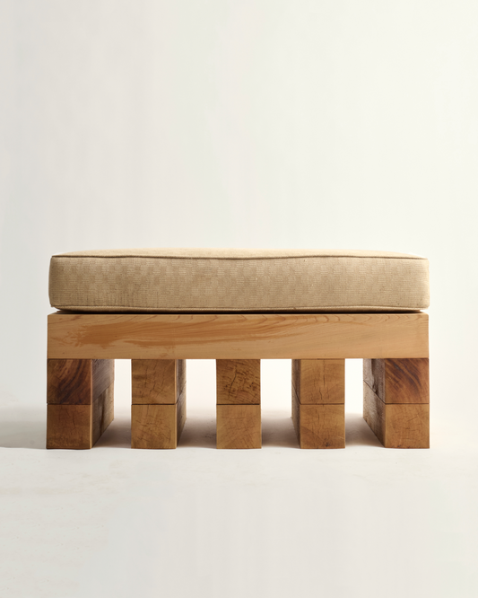Wooden ottoman with a beige cushion on a white background