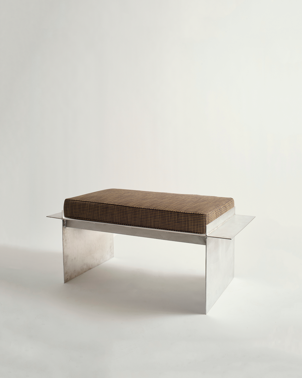 Metal bench with checker board print cushion on white background