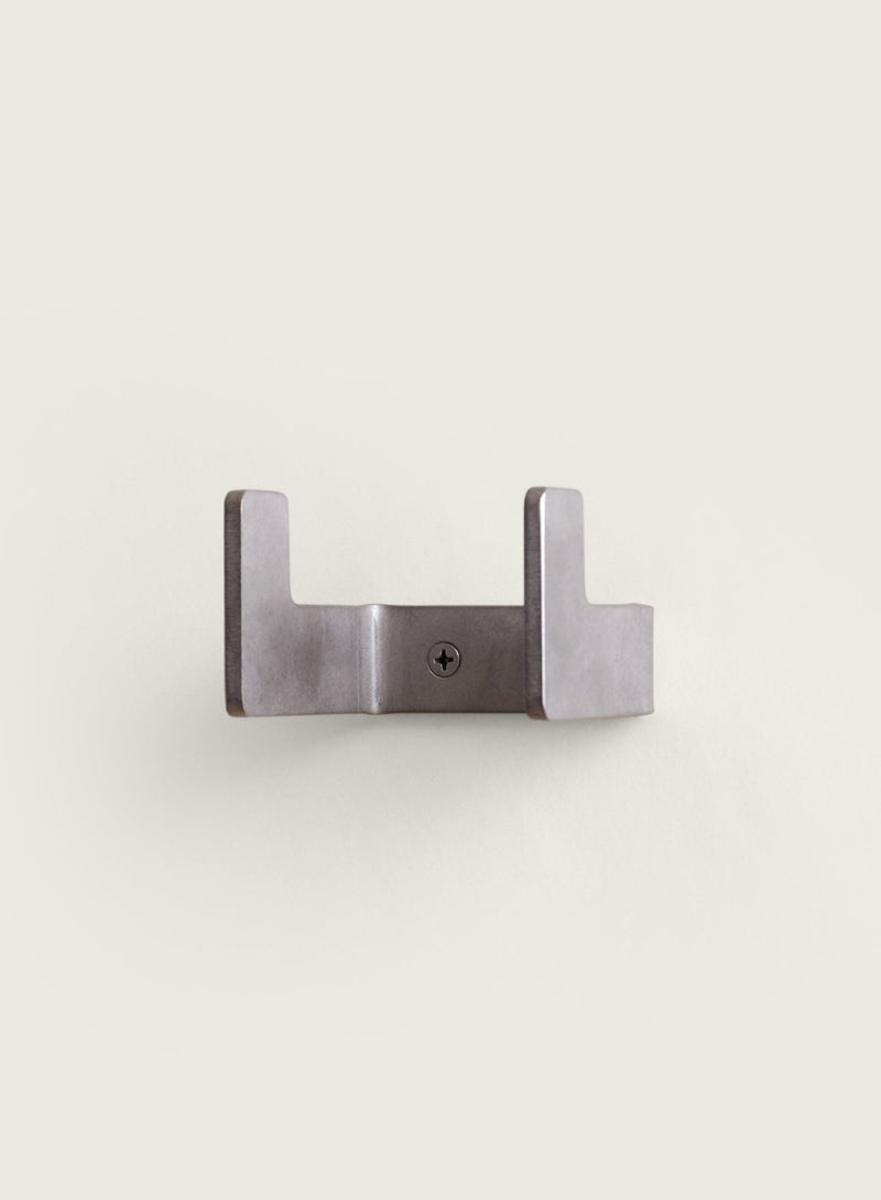 Small silver utility hook on a light beige background