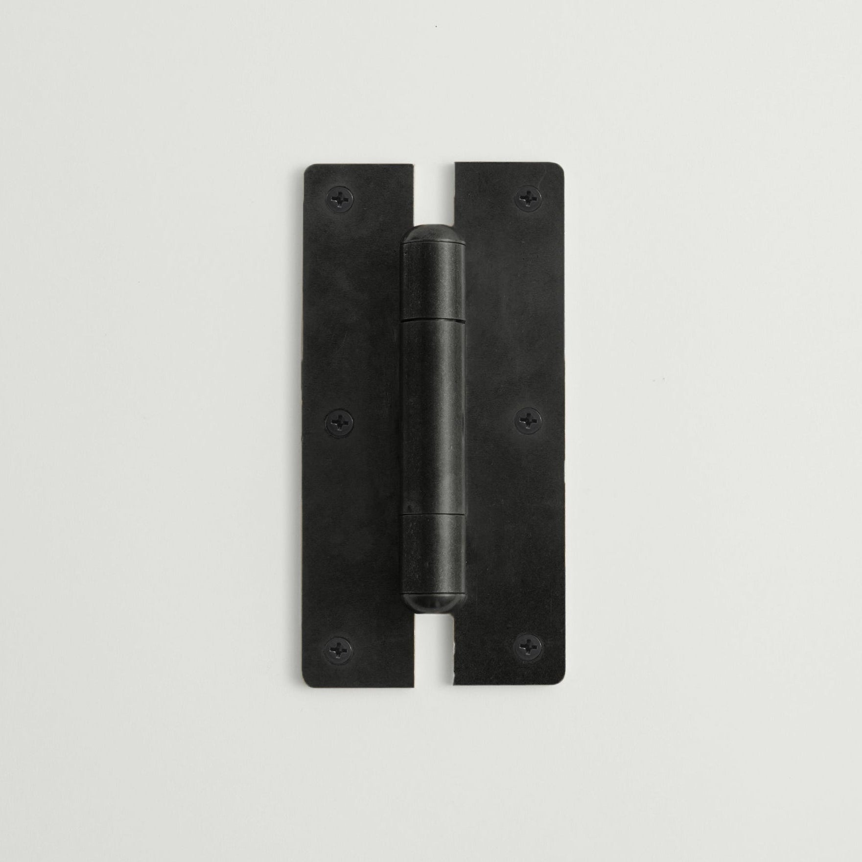Black metal hinge on a light gray background