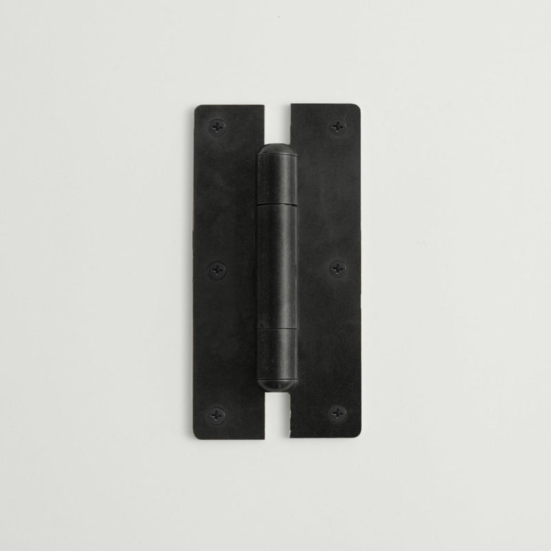 Black metal hinge on a light gray background