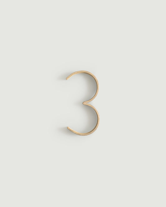 Raw brass house number three