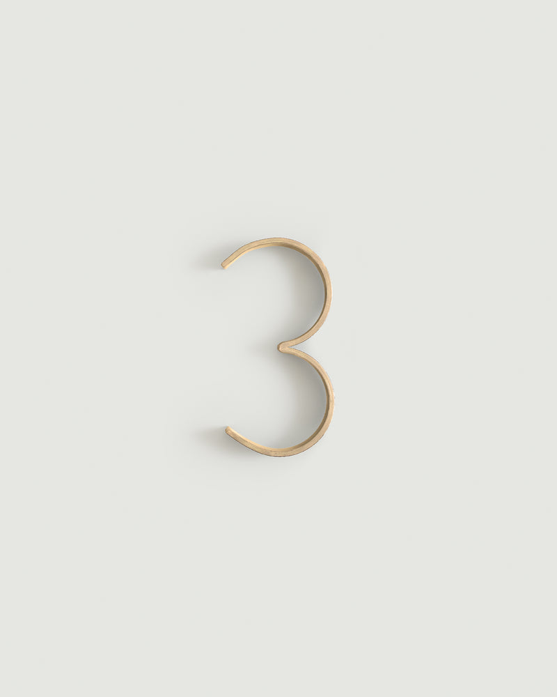 Raw brass house number three