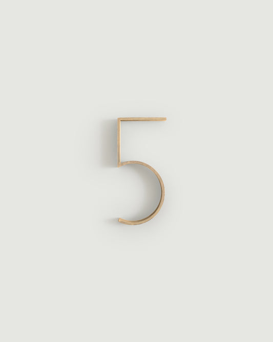 Raw brass house number five