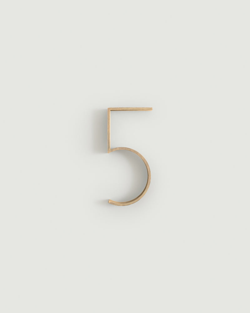 Raw brass house number five