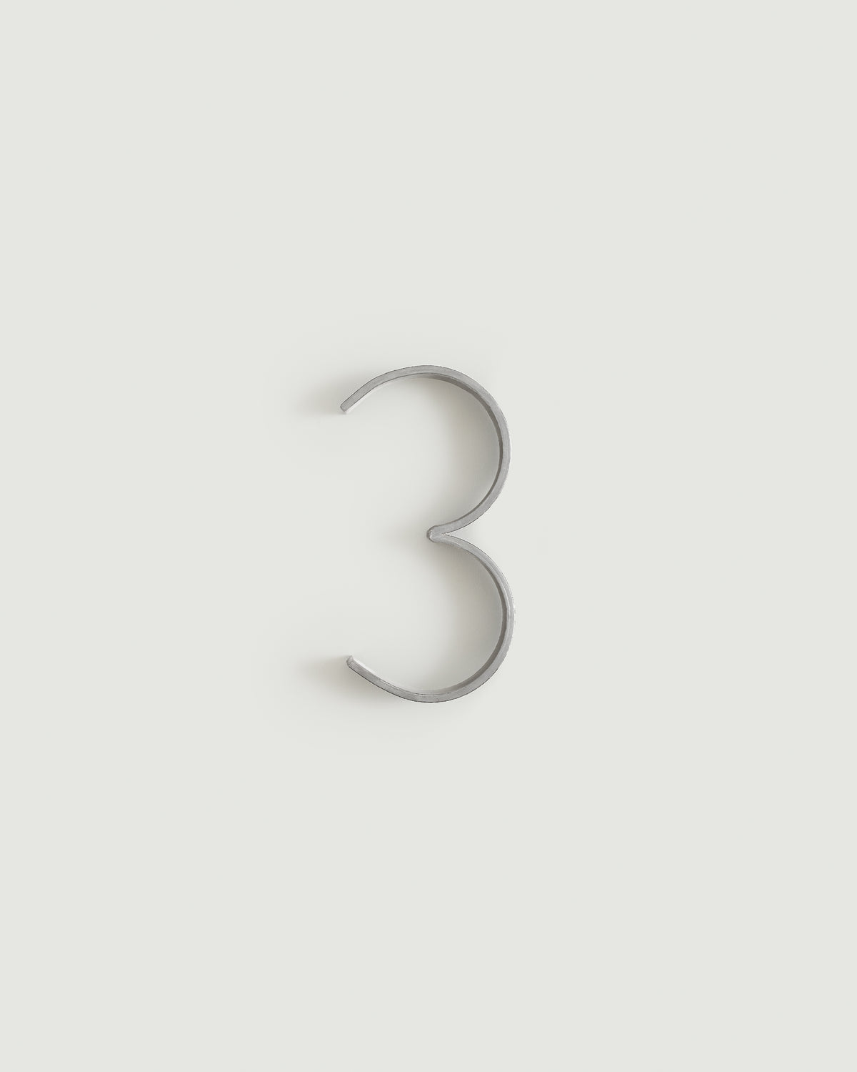 Worn silver house number three