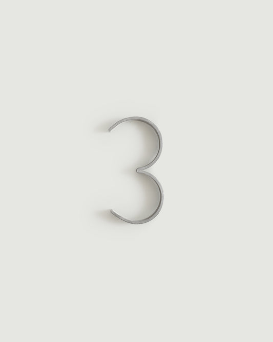 Worn silver house number three