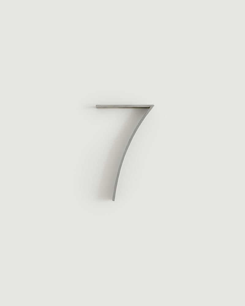 Worn silver house number seven