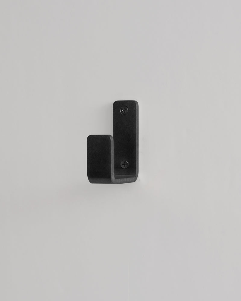 Black metal hook on a light gray background