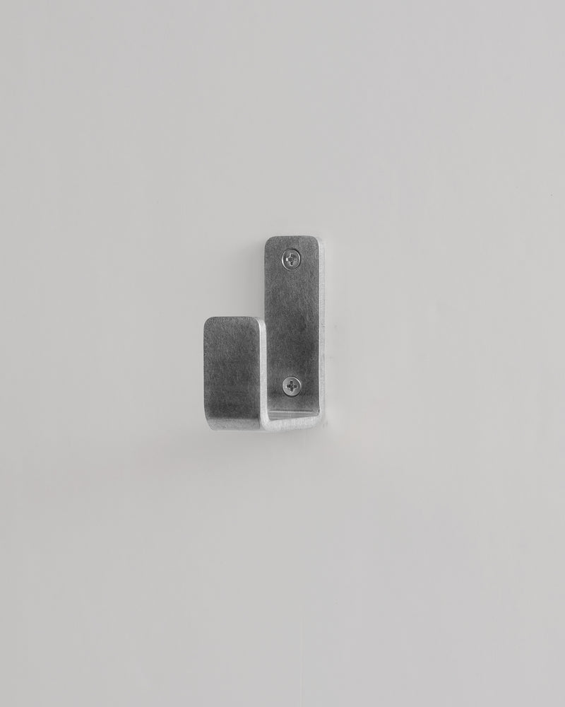 Metallic wall hook on a light gray background