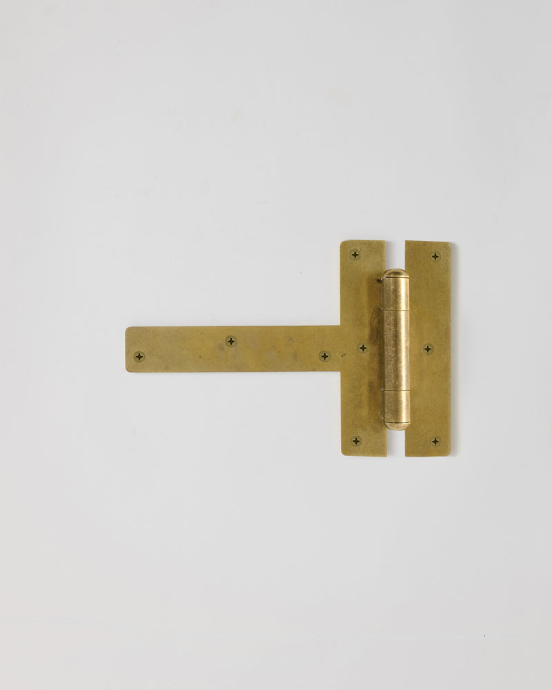 Raw brass door hinge on a white background
