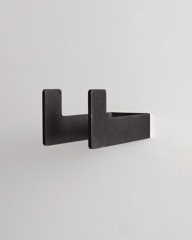 medium blackened brass utility hook on a light gray background