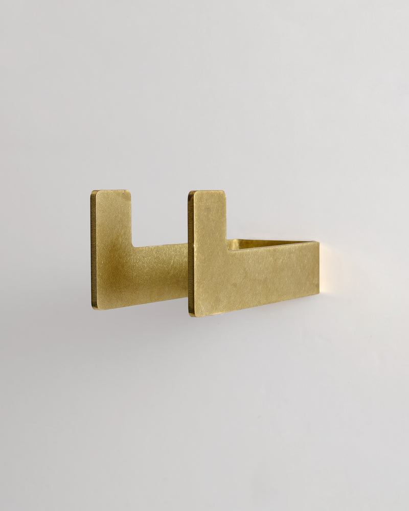 Medium raw brass utility hook on a light gray background