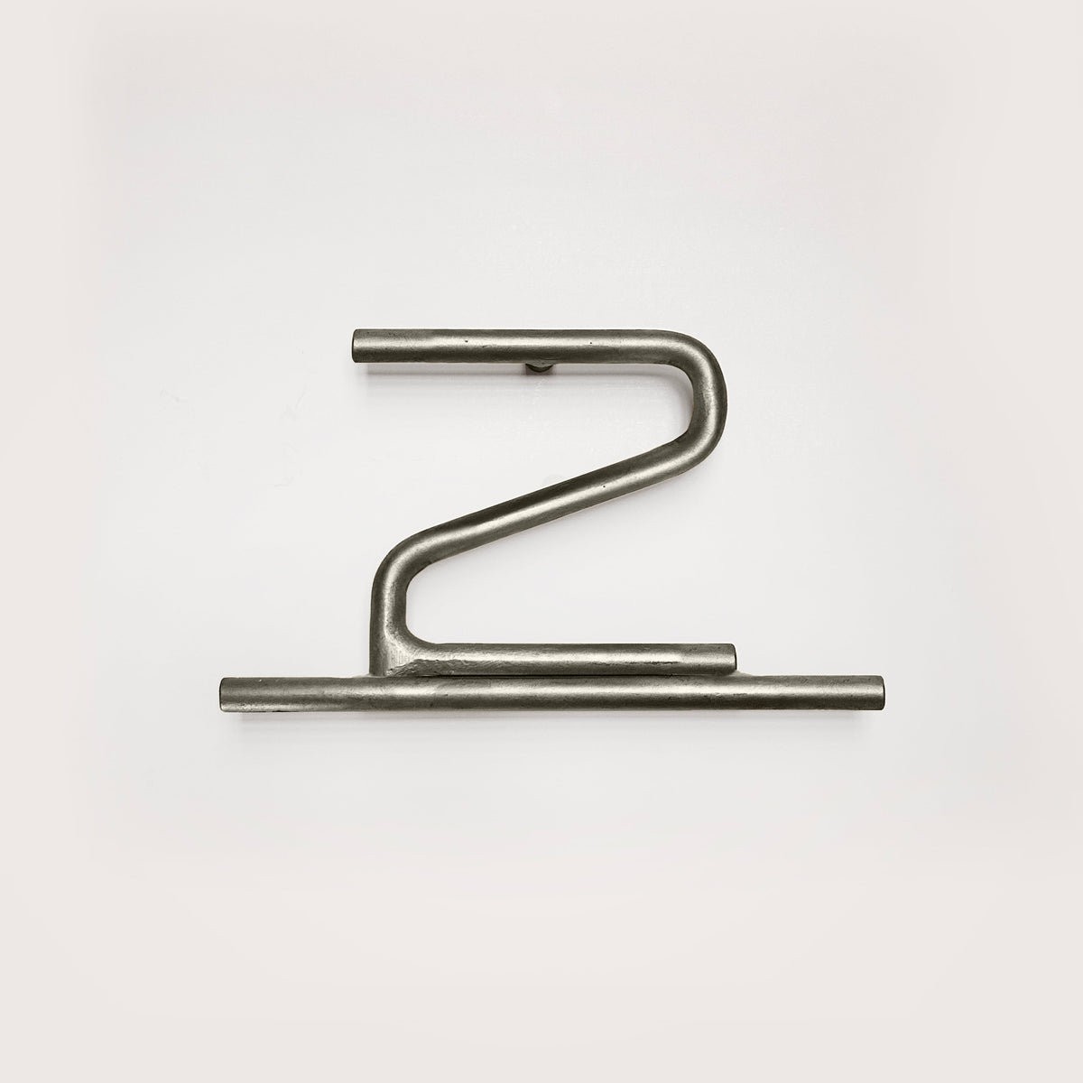 Silver house number '2' on a white wall 