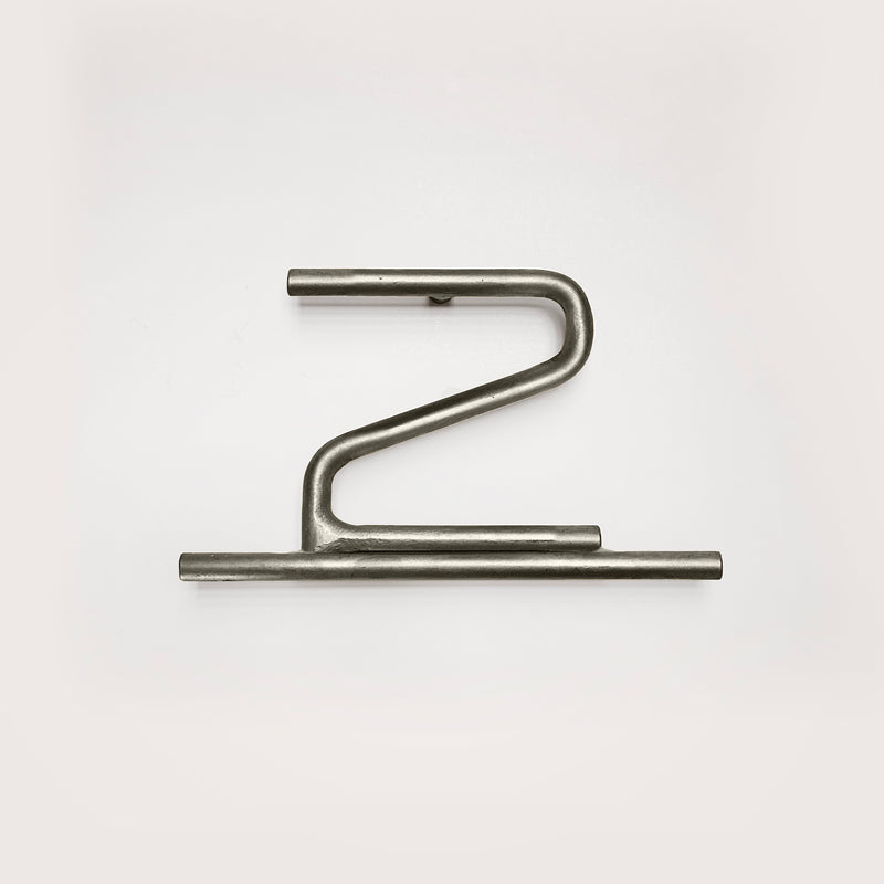 Silver house number '2' on a white wall 