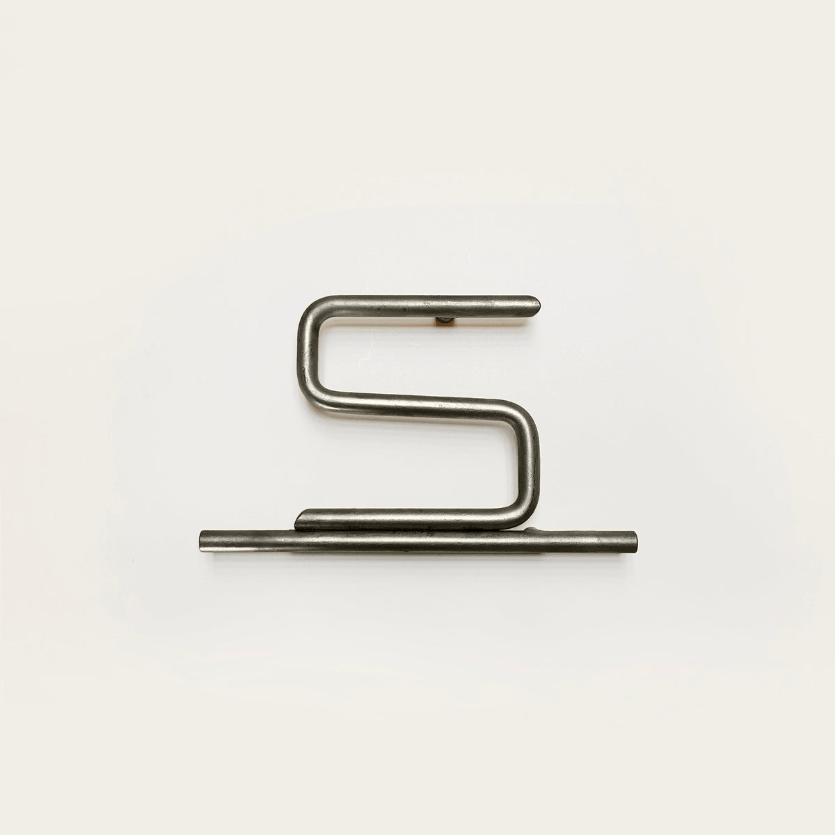 Silver house number '5' on a white wall 