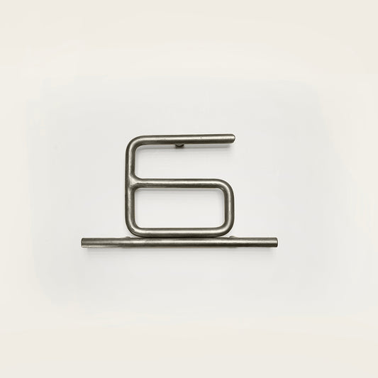 Silver house number '6' on a white wall 