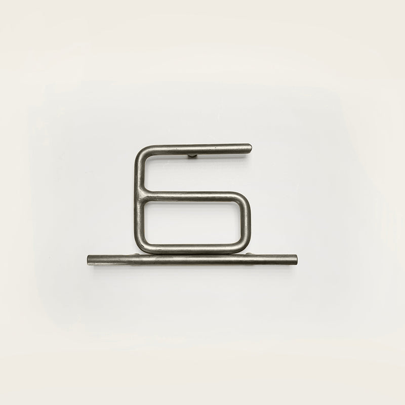 Silver house number '6' on a white wall 