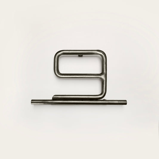 Silver house number '9' on a white wall 