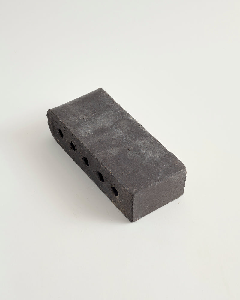Char colored bullnose paver on a white background