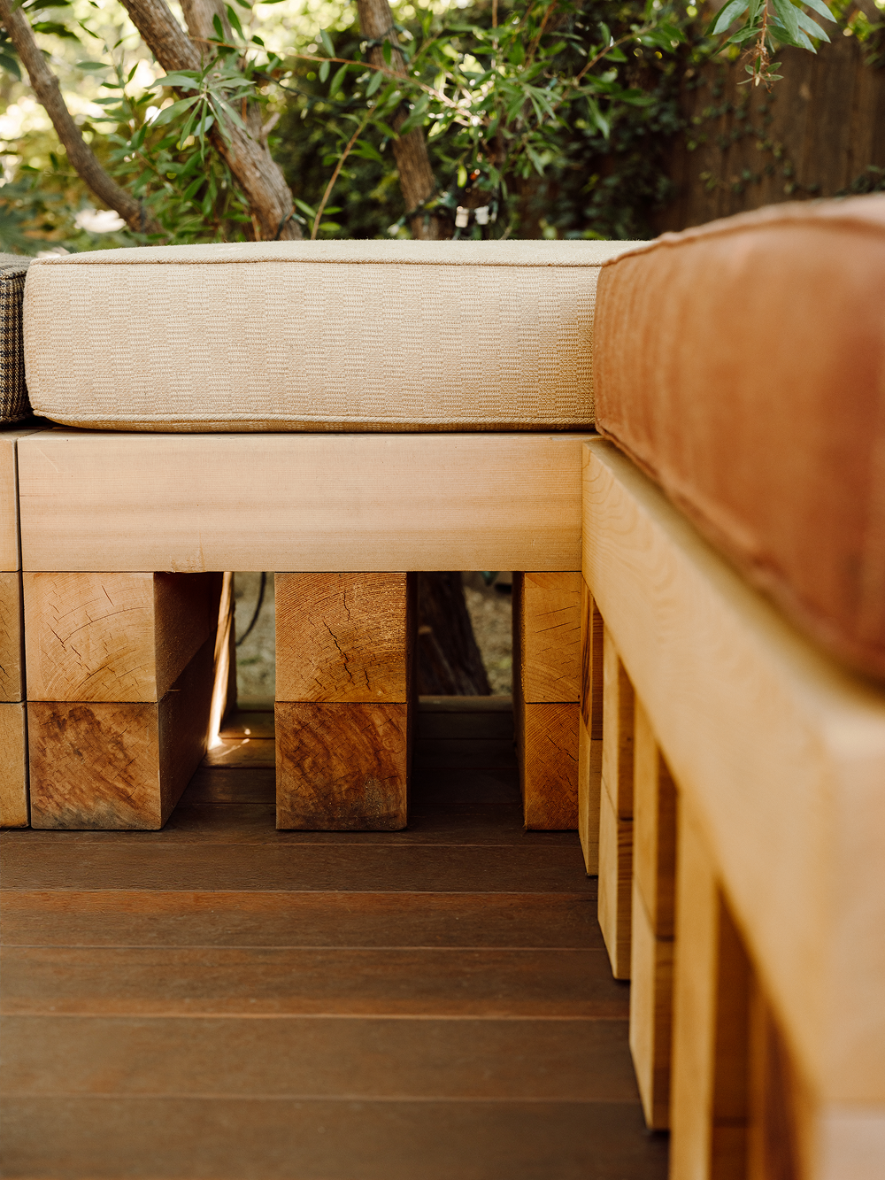 Wooden outdoor furniture with cushions in a natural setting