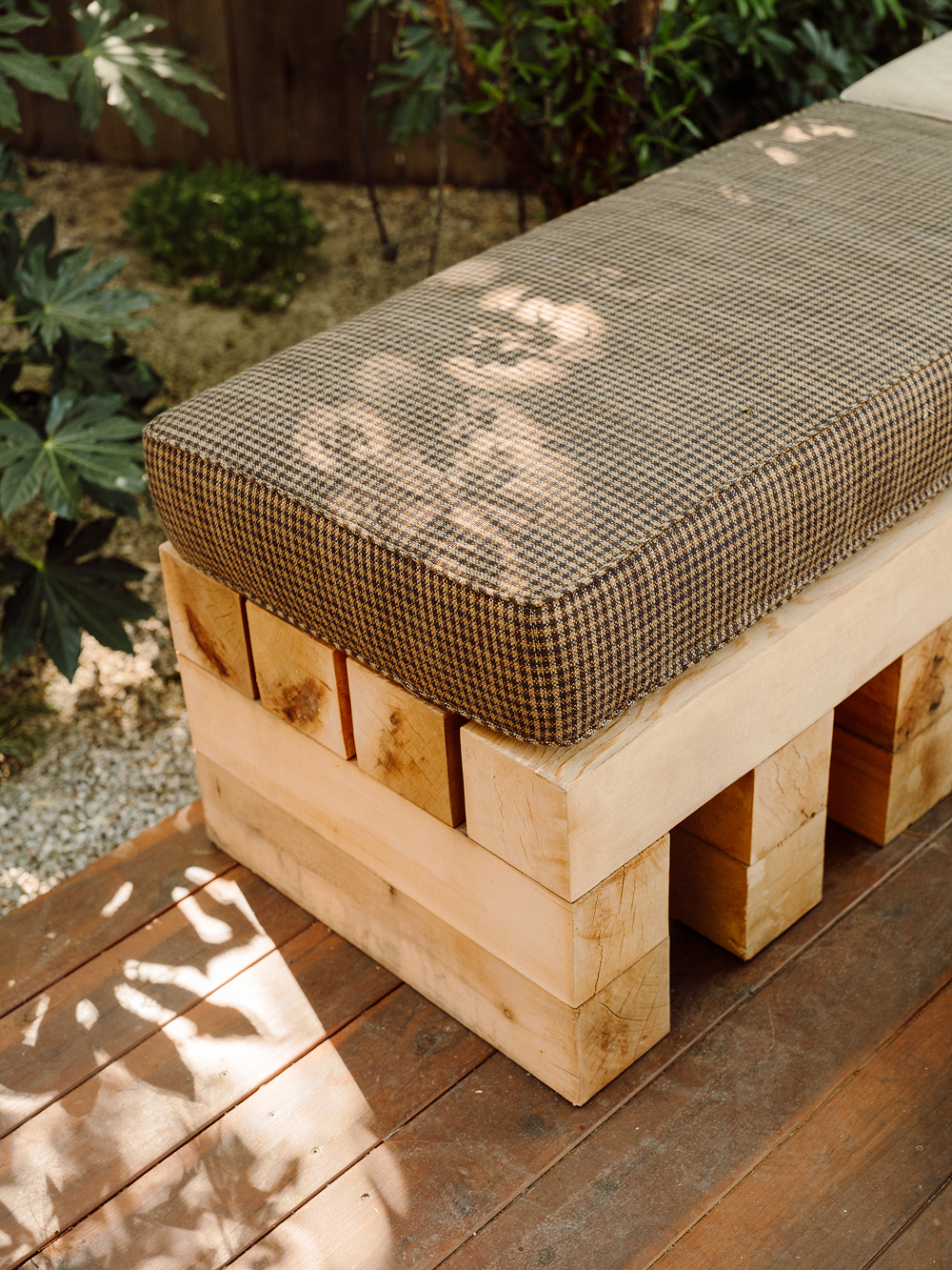 Wooden bench with a cushion on a wooden deck